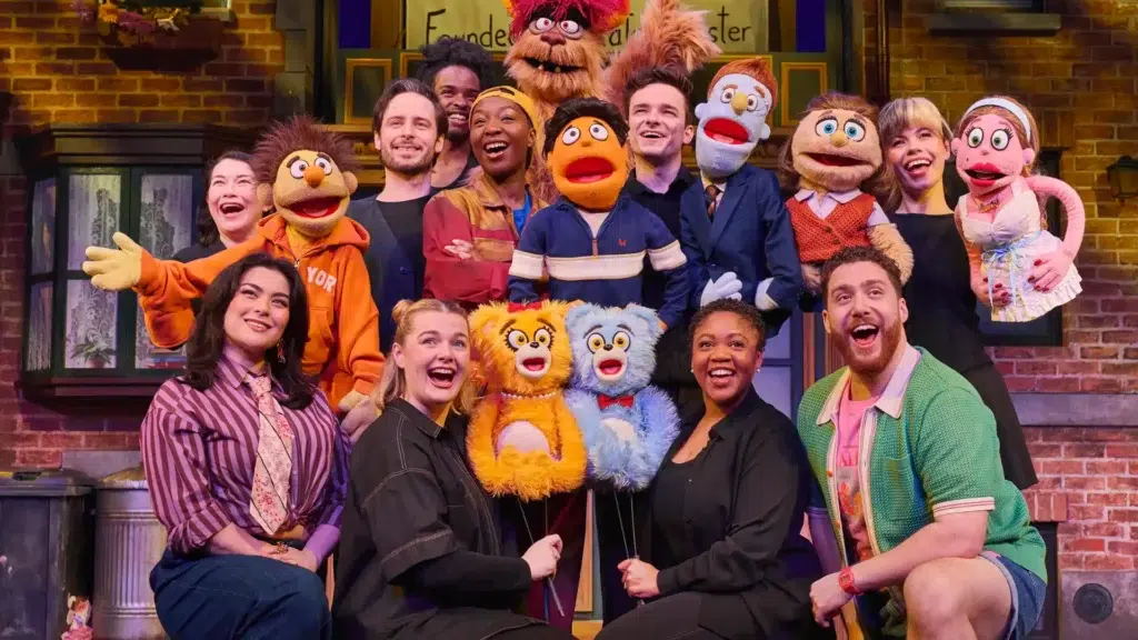 cast of colourful dressed puppets from avenue q musical